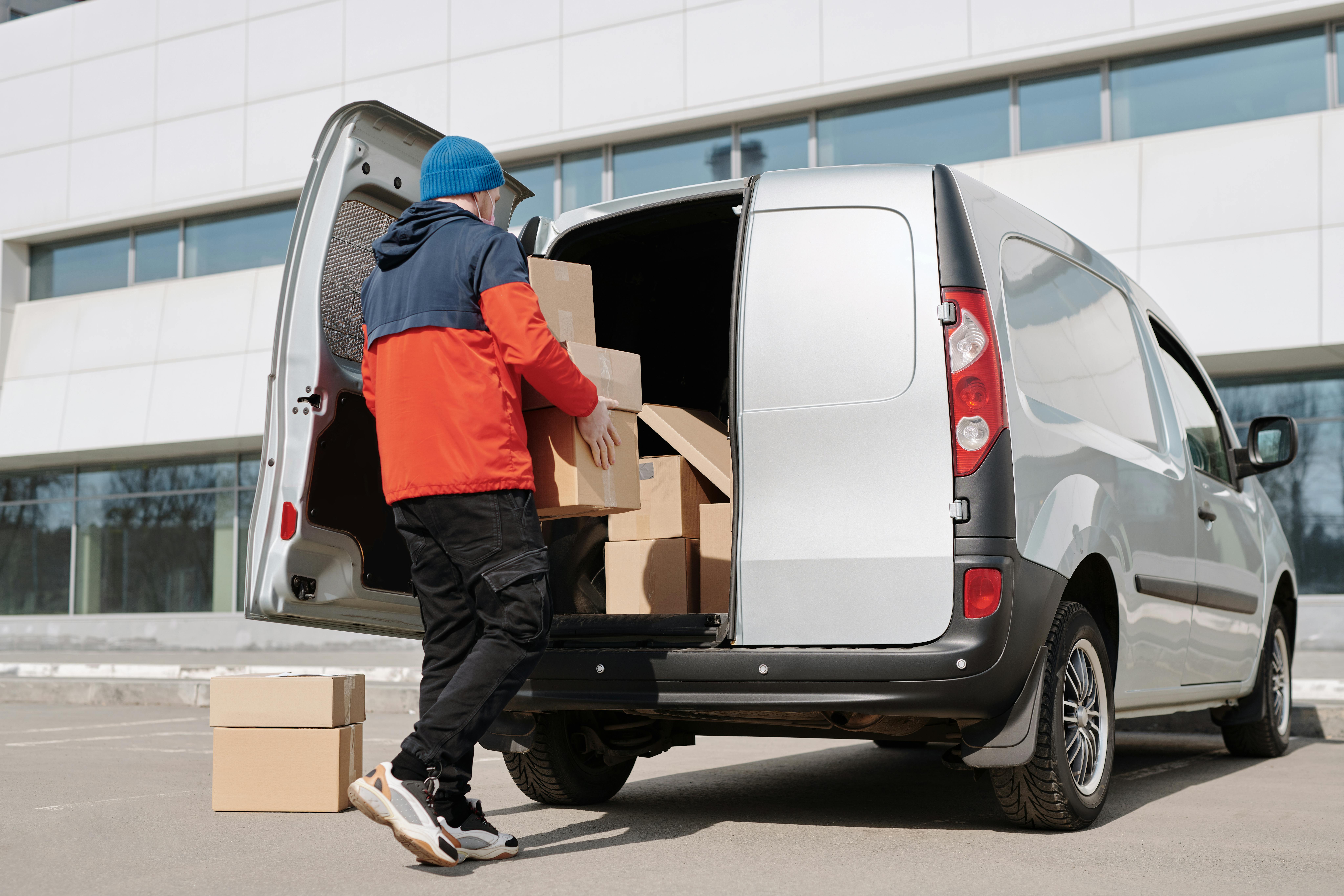 A man putting cardboard boxes in a van