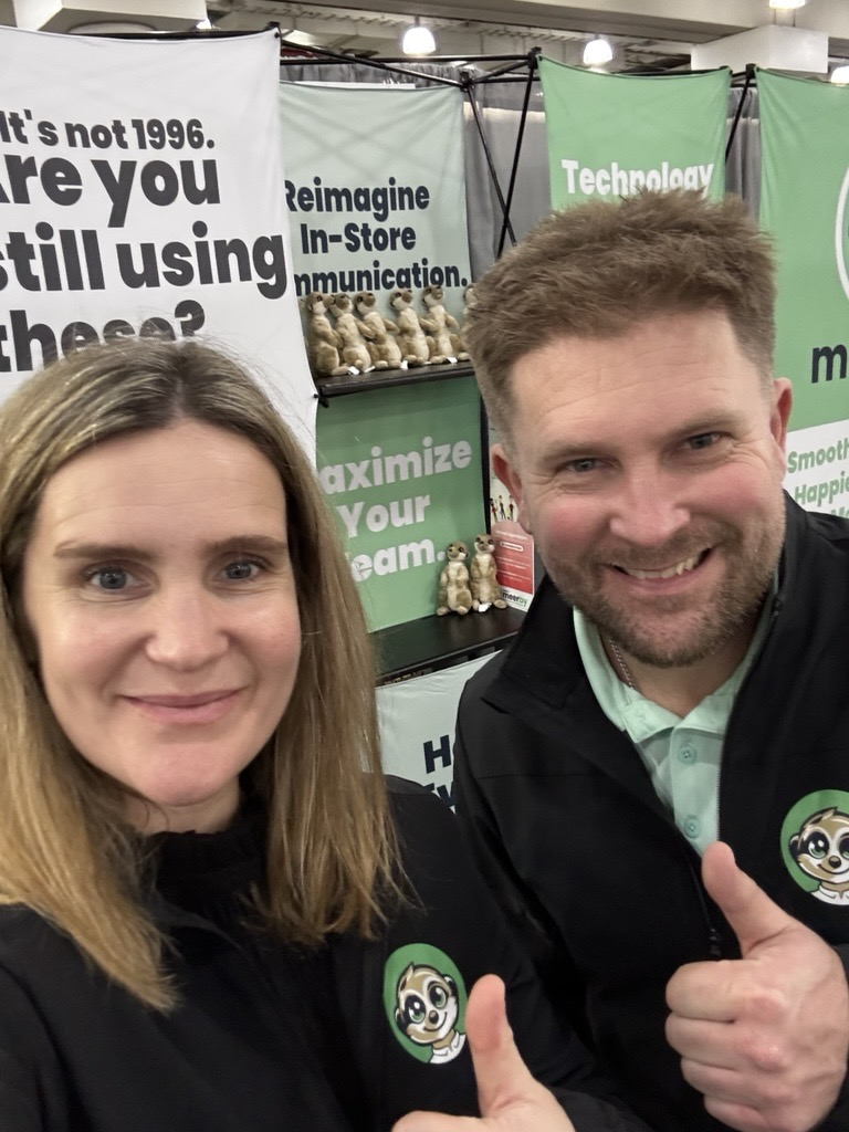 Allan and Liz give a thumbs up in front of a Meerby informational display.