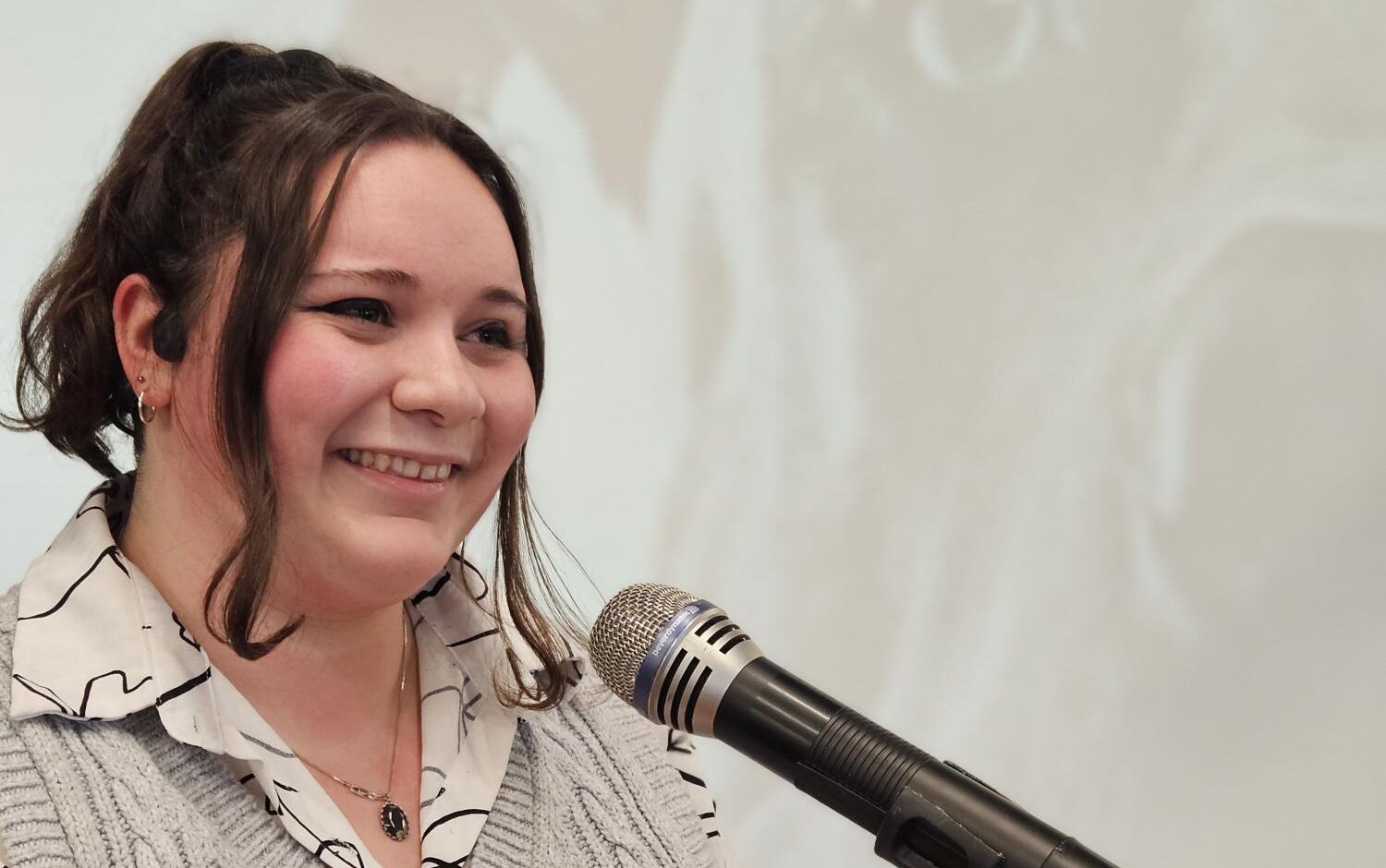 Headshot of Ella Wiggins speaking at podium.